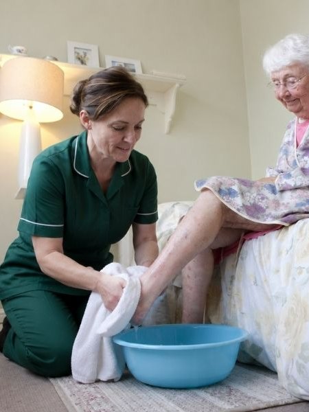Caregiver helping a senior with bathing as part of daily living support