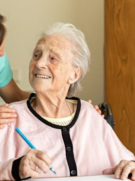 Caregiver reassuring a senior woman living with dementia