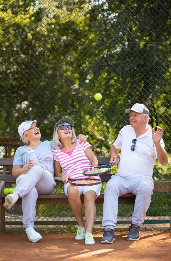 Happy seniors smiling and playing tennis