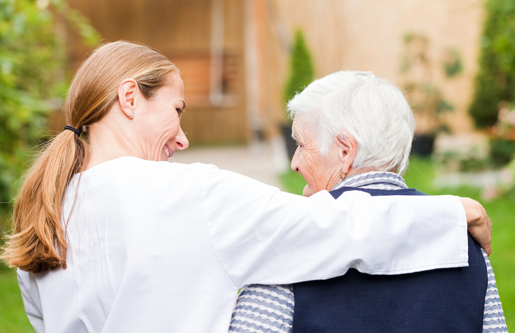 Elderly woman who has Parkinson with her caregiver