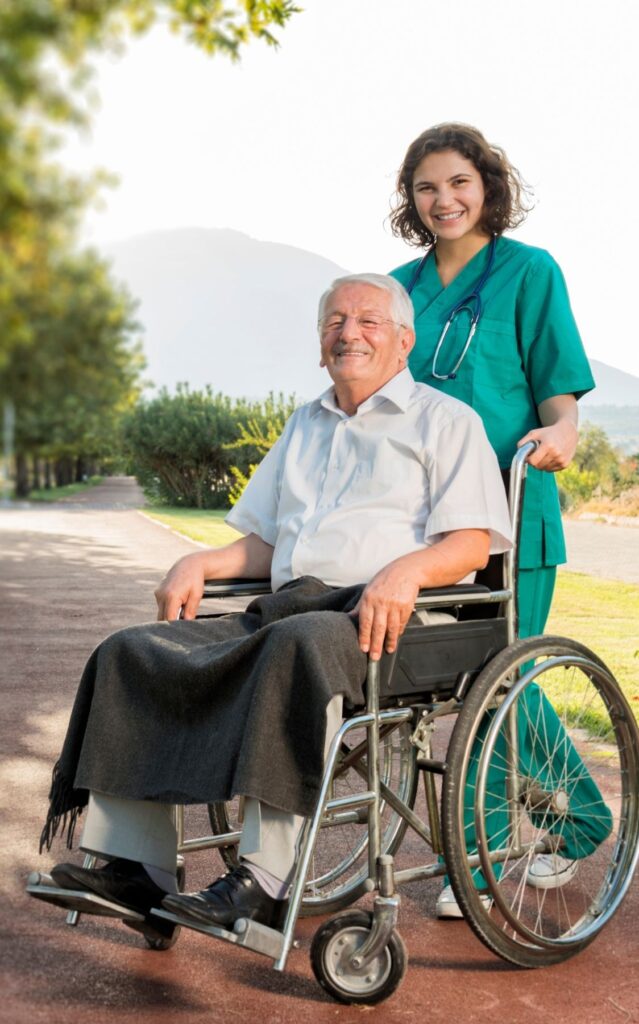 Caregiver taking the senior man for a walk on a wheel chair after his surgery