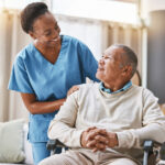 A caregiver smiling at an elderly man