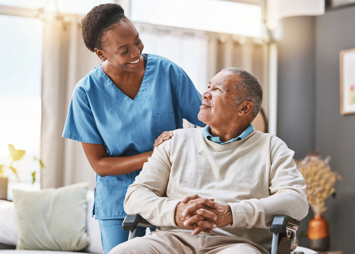 A caregiver smiling at an elderly man