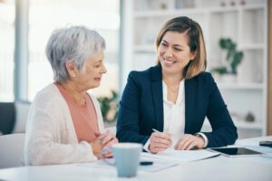 An elderly woman speaking with a younger woman
