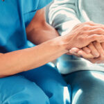 Caregiver holding hands with an elderly patient