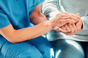 Caregiver holding hands with an elderly patient