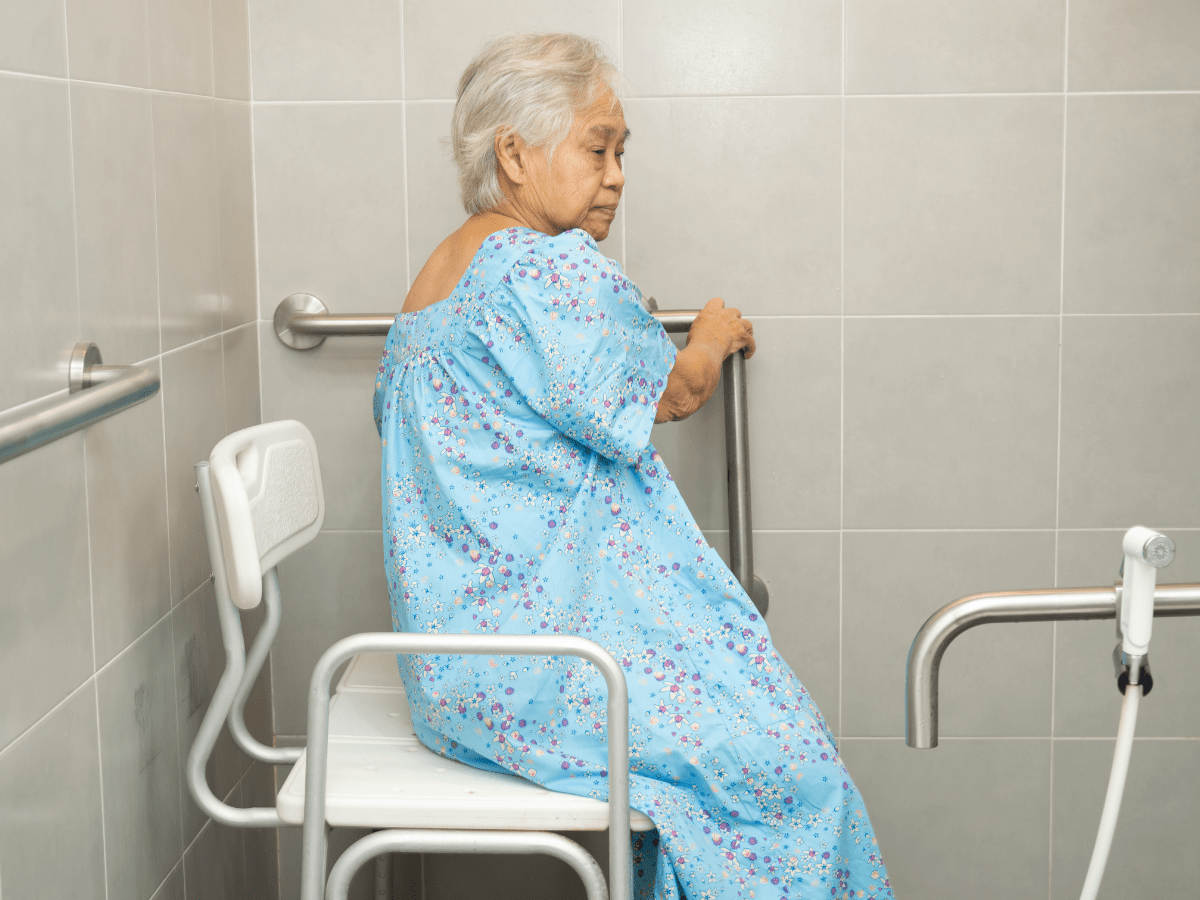 senior sitting in bathroom