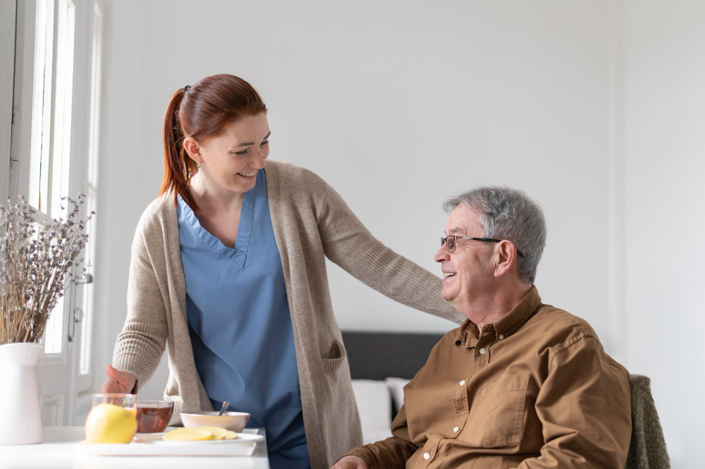 Caregiver giving elderly man breakfast