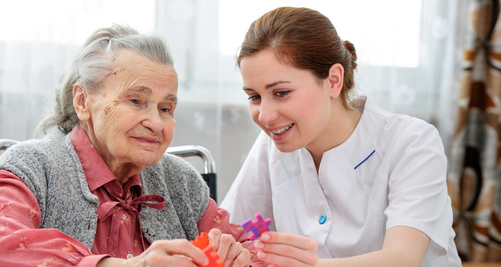 a place at home caregiver working on puzzle with elderly woman