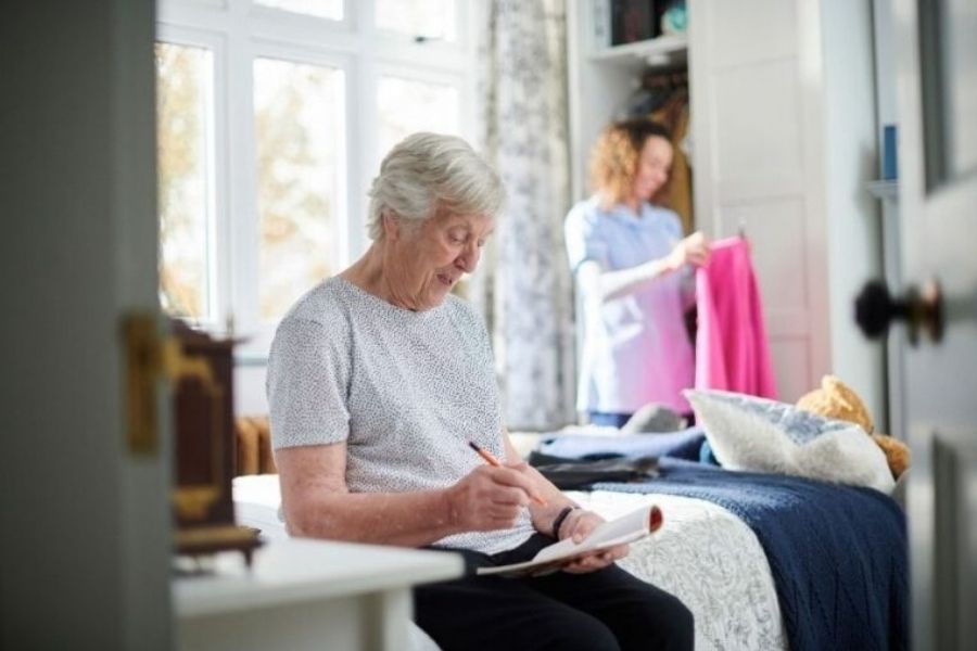 Caregiver helping with light laundry for a senior woman in Los Alamitos, CA