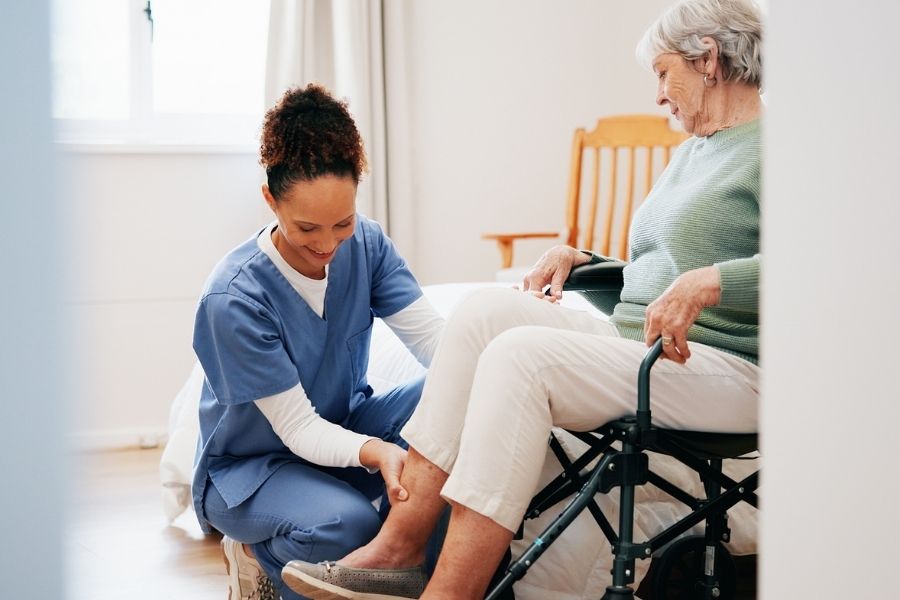 Caregiver helping a senior woman after knee surgery in Los Alamitos, CA