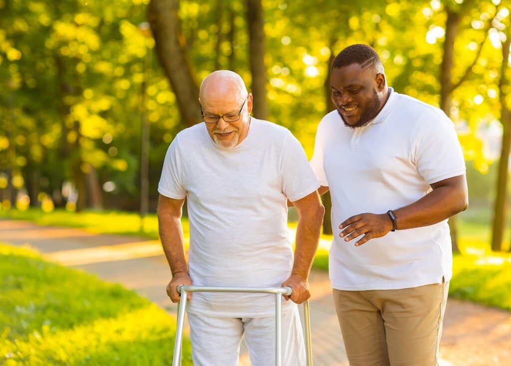 Caregiver walking with a senior man living with Parkinson's in Los Alamitos, CA