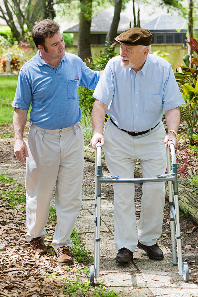 caregiver with elderly man on a walk