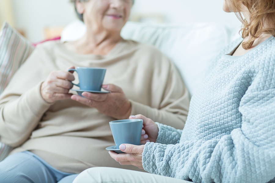 elderly woman and caregiver drinking hot tea