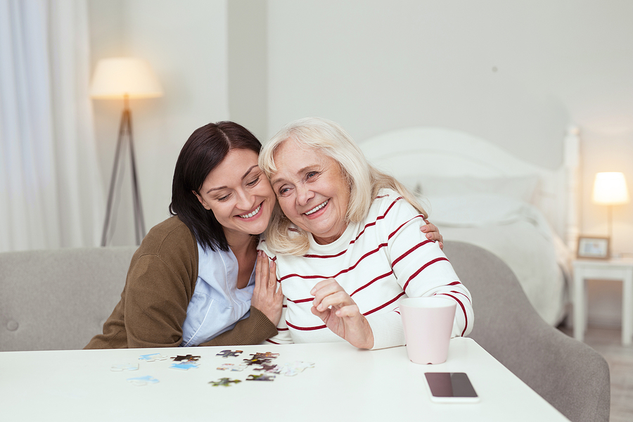 a place at home caregiver working on puzzle with elderly woman