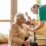 caregiver brushing elderly woman's hair