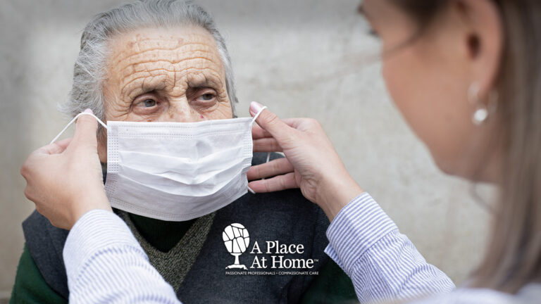 A caregiver helping place a mask on a senior.