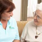 A caregiver from A Place At Home speaks to a senior woman she is assisting.