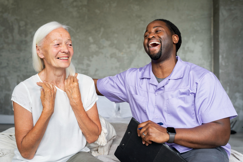 Caregiver and elderly woman laughing together