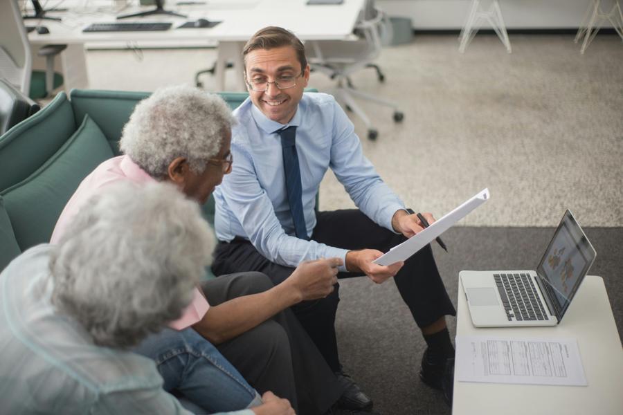 Businessman talking to two elderly people